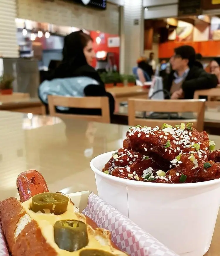 ساندویچ هات داگ پرزل با پنیر و هالوپینو و مرغ سوخاری کره ای. تجربه غذایی لذیذ در فست فود گامبی ساندویچ با محیطی عالی.