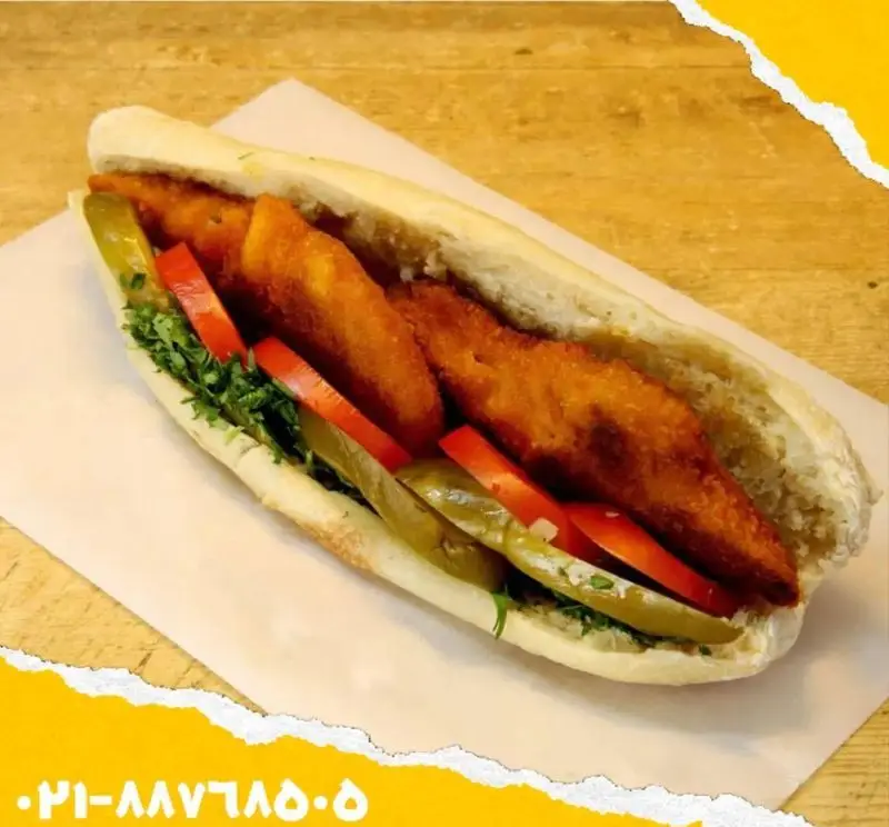 ساندویچ مرغ سوخاری لذیذ و پرطرفدار اغذیه یگانه، همراه با سبزیجات تازه، خیارشور و فلفل دلمه‌ای، یک گزینه عالی فست فود برای شما.