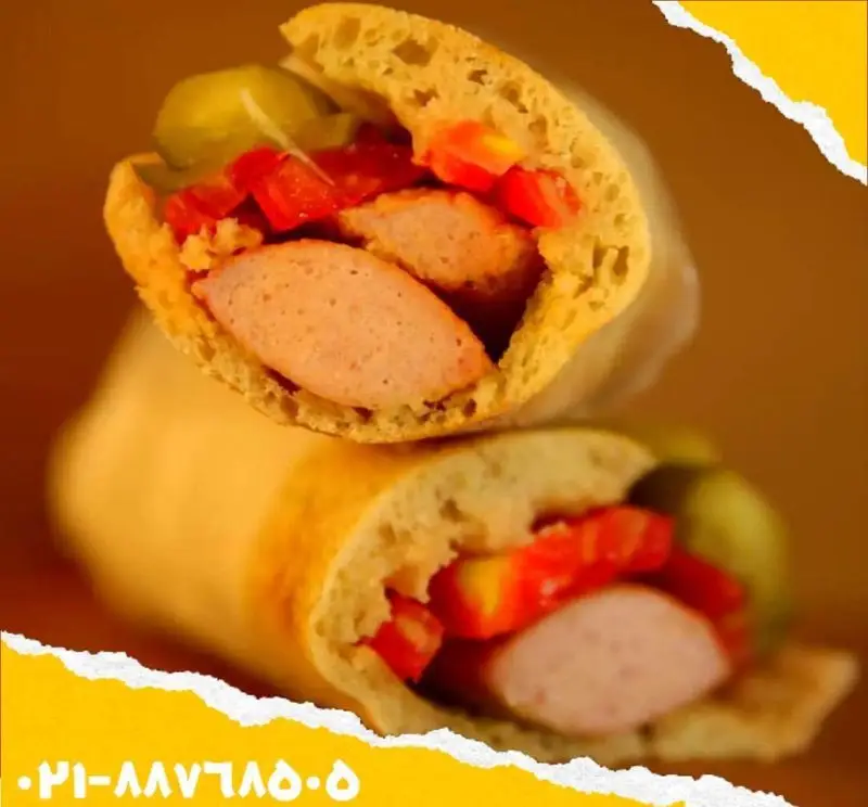 ساندویچ سوسیس و هات‌داگ ویژه اغذیه یگانه با گوجه، خیارشور و نان تازه. تجربه‌ای لذیذ و سریع برای مشتریان.