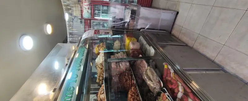 ویترین اغذیه یگانه با انواع کالباس، سوسیس، و فرآورده‌های پروتئینی تازه. نورپردازی روشن و محصولات غذایی آماده به فروش.