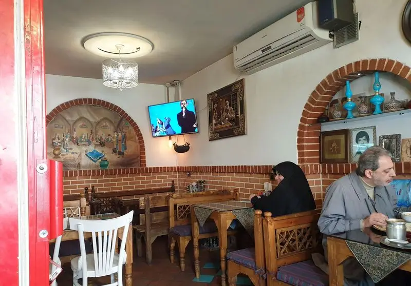 فضای دلنشین جگرکی عمو فیضی: محیطی سنتی با دکور آجری، نقاشی اصیل ایرانی و مشتریانی که از طعم لذیذ جگر تازه در حال لذت بردن هستند.