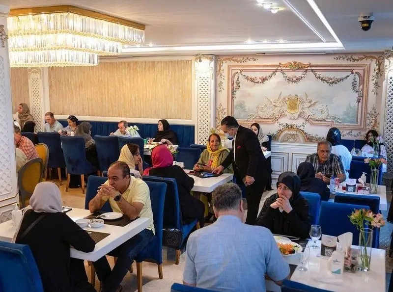 فضای داخلی شیک و دلنشین رستوران محسن با میهمانان در حال سرو غذا، ایده‌آل برای یک تجربه غذایی لوکس و خاطره‌انگیز در محیطی آرام.