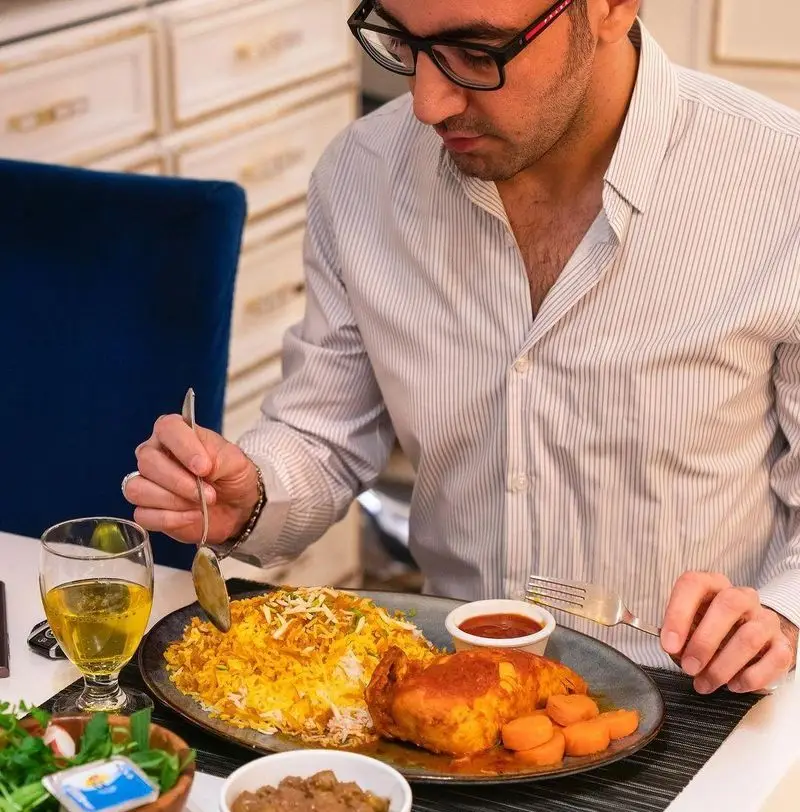 تصویری از مشتری در حال میل کردن چلو مرغ زعفرانی و خوش‌طعم در محیطی آرام و دلپذیر رستوران محسن؛ تجربه‌ای به یاد ماندنی.
