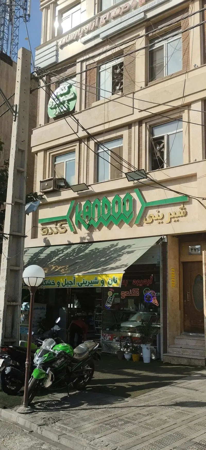 نمای بیرونی شیرینی کندو، یک قنادی و نانوایی معروف در ایران با انواع شیرینی، آجیل، خشکبار و آبمیوه. تابلو سبز رنگ کندو.