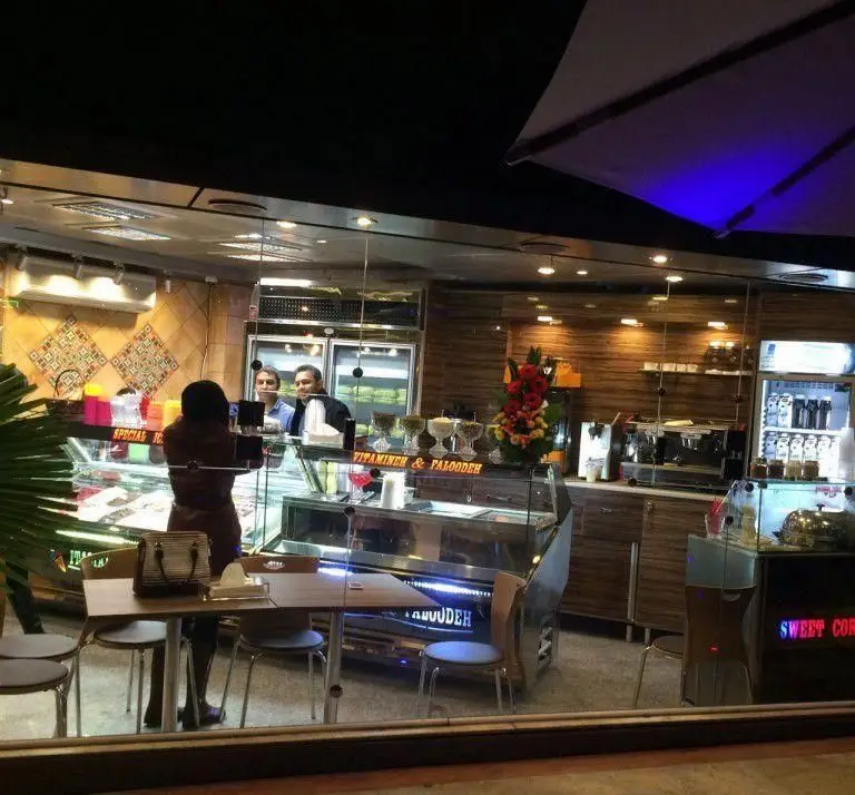 محیط دلنشین و داخلی آبمیوه بستنی شاهو: مشتریان در حال سفارش بستنی، فالوده، آبمیوه تازه و نوشیدنی‌های ویتامینه از پیشخوان پرمحصول.