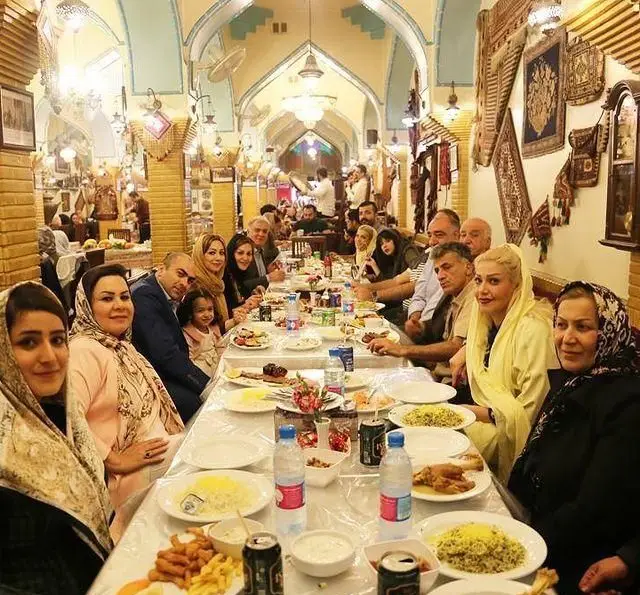 دورهمی شاد خانوادگی در سفره خانه سنتی باغ فردوس با فضای دلنشین و معماری سنتی ایرانی، لذت صرف غذا و خاطره سازی.