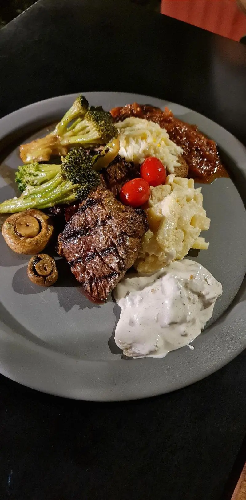استیک گریل شده حرفه‌ای با مخلفات لذیذ شامل بروکلی، قارچ و پوره، تجربه‌ای بی‌نظیر از منوی کافه تی آرت.