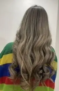 عکس مدل موی بلند زنانه با رنگ موی بلوند دودی و هایلایتهای روشن همراه با کرلی ملایم، نمونه کار رنگ و لایت حرفهای