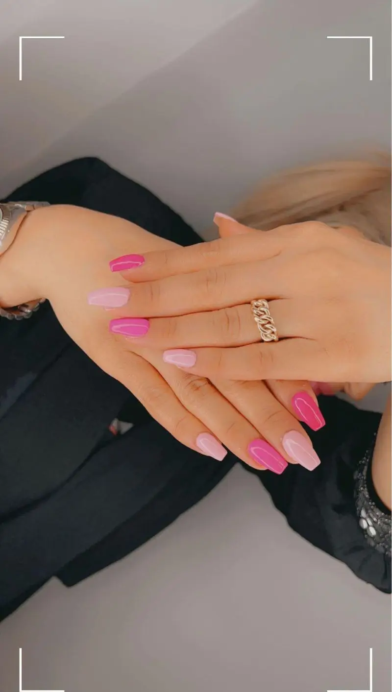 کاشت ناخن شیک و زیبا با ترکیب رنگهای صورتی و صورتی کمرنگ روی دستان، خدمات حرفهای در سالن زیبایی و تخصصی کاشت ناخن الا.