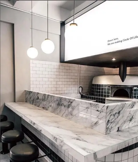 دکوراسیون داخلی زیبای رستوران فرسکو با پیشخوان مرمر، کاشی‌های سفید مترو و اجاق پیتزا سنگی، فضایی مدرن و دلنشین ایجاد کرده است.