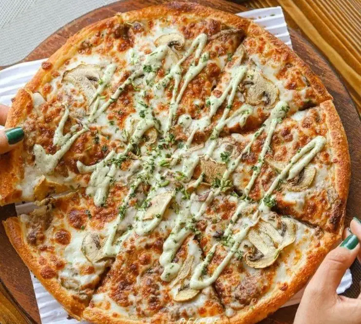 پیتزای قارچ و پنیر طلایی فست فود د ل پ با سس سبز، سبزیجات معطر و طعمی بی‌نظیر. گزینه‌ای عالی برای سفارش شما!