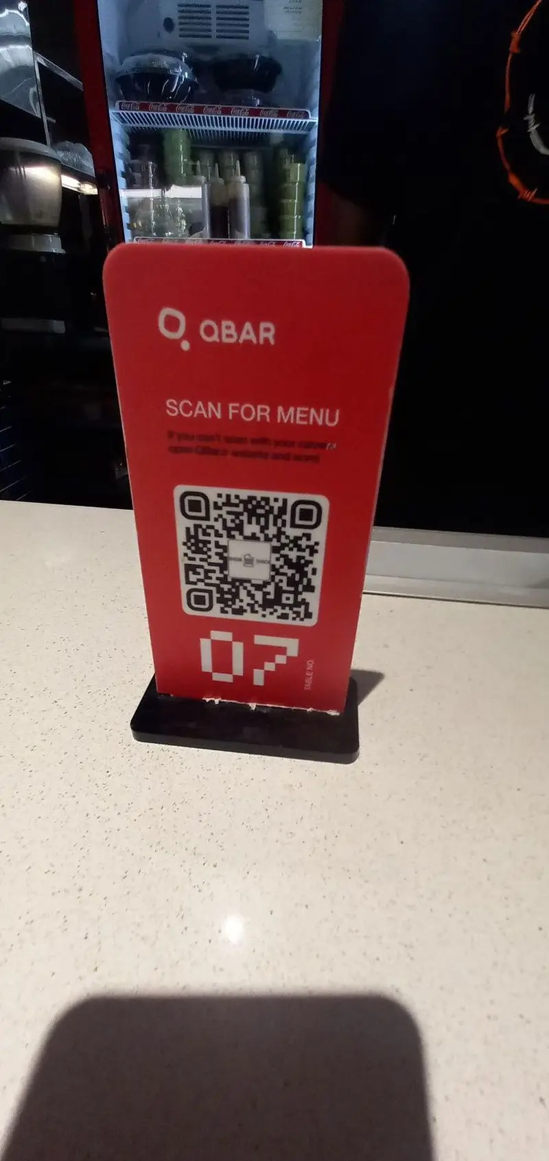پایه رومیزی منوی دیجیتال QBAR (شیک شک) با QR کد، شماره میز 07 و یخچال پر از غذا. اسکن برای مشاهده منو.