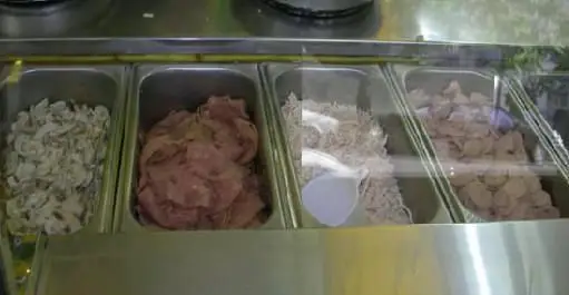 نمایش مواد اولیه تازه و متنوع پیتزا مدبر: قارچ اسلایس شده، ژامبون، مرغ ریش ریش شده و تکه های مرغ برای پیتزا و ساندویچ