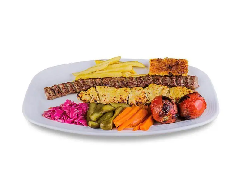 غذای ایرانی شامل کباب کوبیده، جوجه کباب، سیب زمینی سرخ کرده، ته دیگ، گوجه کبابی، ترشی و خیارشور از رستوران صدر سان (شعبه فاطمی).