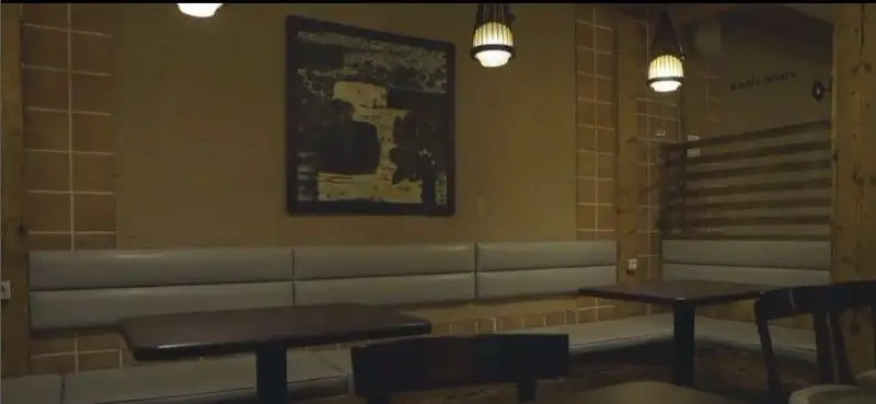 فضای داخلی کافه فلوره: محیطی آرام با دکوراسیون شیک، شامل نیمکت‌های راحت، میزهای چوبی و چراغ‌های آویز مدرن برای یک تجربه دلپذیر.