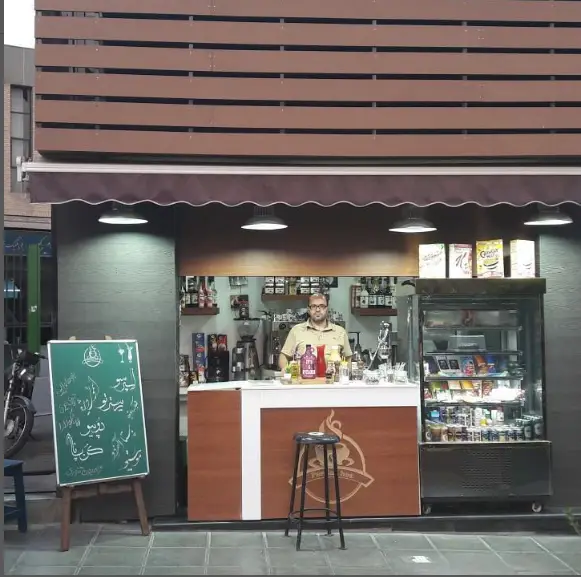 نمایی از کافه پرشین، یک فروشگاه قهوه دنج با باریستایی حرفه ای در حال ارائه نوشیدنی و قهوه، همراه با منوی متنوع و خدمات ویژه.