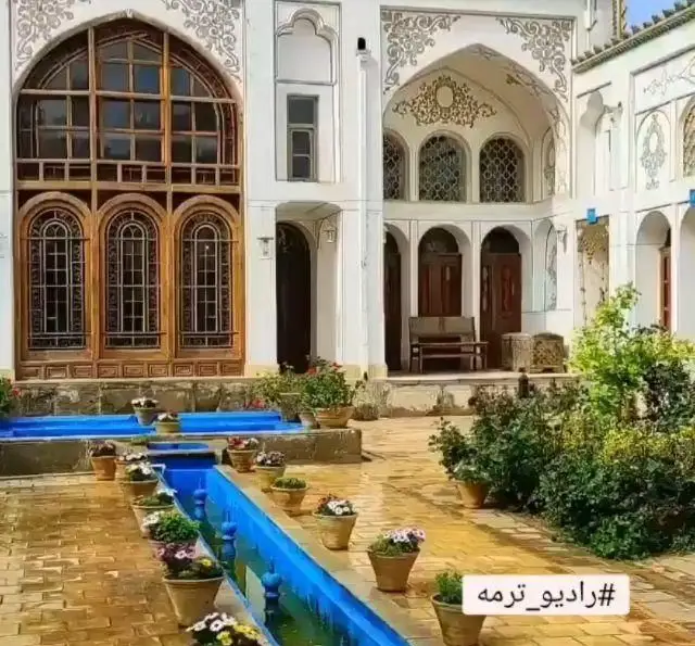 فضای دلنشین رستوران سنتی ترمه با معماری چشم‌نواز خانه تاریخی، حیاط سرسبز، حوض آبی و گلدان‌های زیبا.