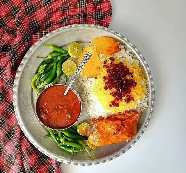 یک وعده غذای سنتی ایرانی در رستوران سنتی ترمه: چلو مرغ زعفرانی، زرشک پلو، خورشت، سیب زمینی، فلفل سبز و لیموترش.