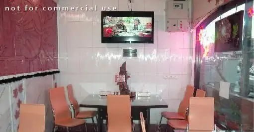 فضای داخلی دلنشین فست فود ماه تولد با میز و صندلی‌های راحت، تلویزیون دیواری و دکوراسیون مدرن برای تجربه غذایی لذت‌بخش.