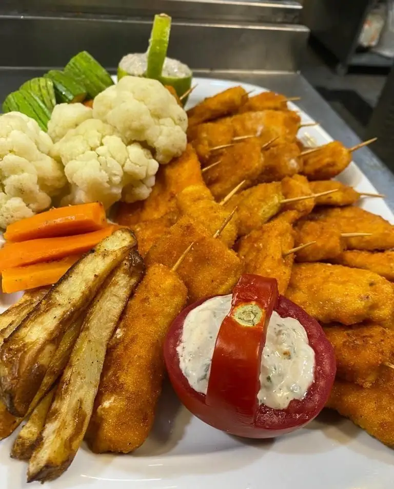 سینی غذای کترینگ لاوان شامل مرغ سوخاری، سیب‌زمینی سرخ‌کرده، سبزیجات بخارپز و گوجه پر سس، مناسب تهیه غذا و مجالس.