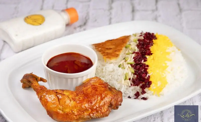 غذای خوشمزه کترینگ لاوان: زرشک پلو با مرغ مجلسی، به همراه ته دیگ و سس، انتخابی عالی برای سفارش غذای خانگی و سنتی ایرانی.