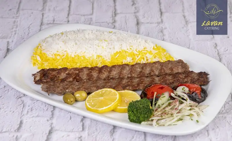عکس چلوکباب کوبیده لذیذ کترینگ لاوان با برنج زعفرانی، گوجه کبابی، لیمو، زیتون، پیاز و بروکلی تازه برای سفارش آنلاین.