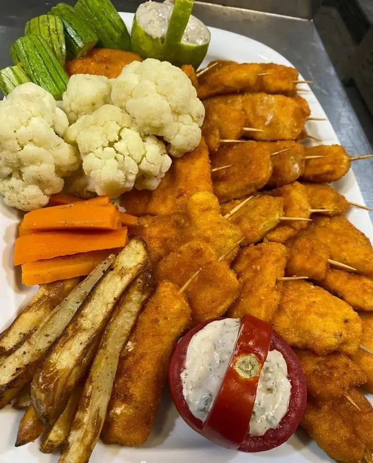 سینی پذیرایی فینگر فود لوکس کترینگ لاوان: چیکن استریپس، سیب زمینی سرخ کرده، سبزیجات بخارپز، دیپ ماست و خیار.
