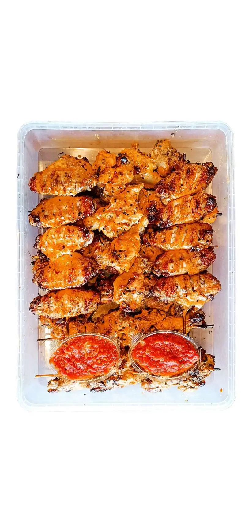 هایپر فود مزه بازار: ظرفی پر از بال و کتف مرغ کبابی طلایی و آبدار با دو ظرف سس قرمز، آماده سفارش آنلاین.