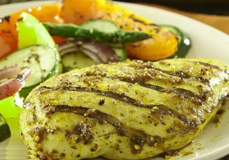 بشقاب مرغ گریل رژیمی و سالم از منوی فست فود چیکولند، همراه با سبزیجات تازه گریل شده و سس مخصوص.