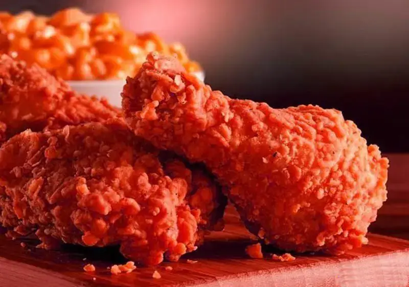 دو تکه ران مرغ سوخاری کریسپی و خوشرنگ فست فود چیکولند در کنار ساید دیش لذیذ، تجربه یک غذای فست فودی بی‌نظیر.