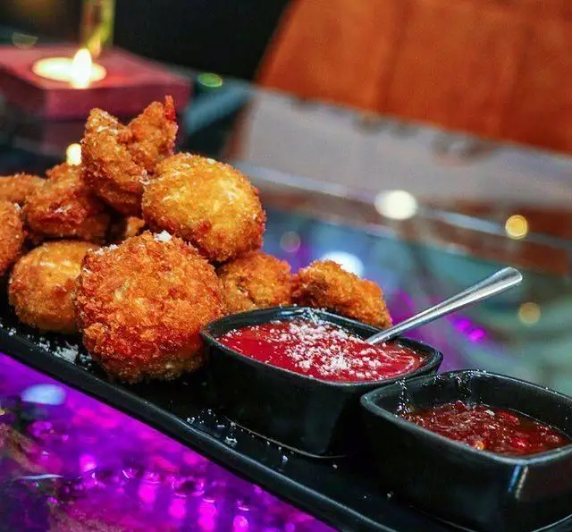 فینگر فودهای ترد و خوشمزه کافه چوب سبز؛ توپک‌های پنیری طلایی همراه با دو نوع سس گوجه مخصوص و پنیر پارمزان، انتخابی عالی برای شما.