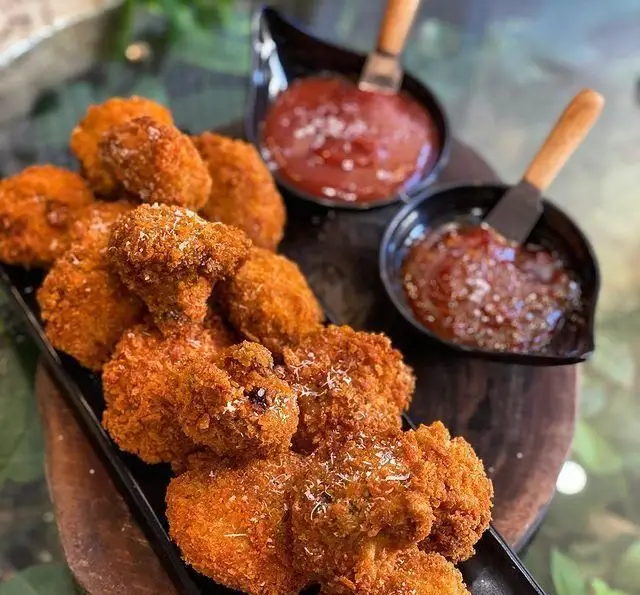 قارچ سوخاری طلایی کافه چوب سبز، سرو شده با سس کچاپ و سس چیلی شیرین، انتخابی دلپذیر برای تجربه طعم.