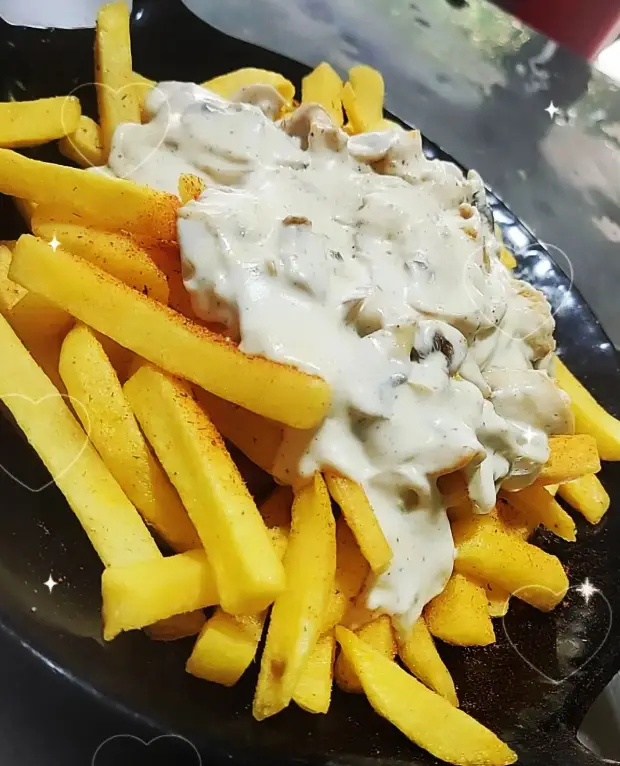 تصویر سیب زمینی سرخ کرده طلایی و خوشمزه با سس قارچ خامه‌ای و تکه‌های قارچ. غذایی محبوب از تهیه غذای شباهنگ.