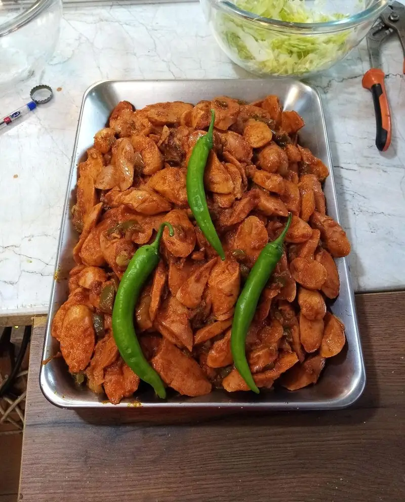 سینی بزرگ سوسیس و کالباس طعم دار شده با سس مخصوص و فلفل سبز تازه، آماده برای پیتزا کوهسار. کیفیت و طعم بی نظیر در پیتزا کوهسار.