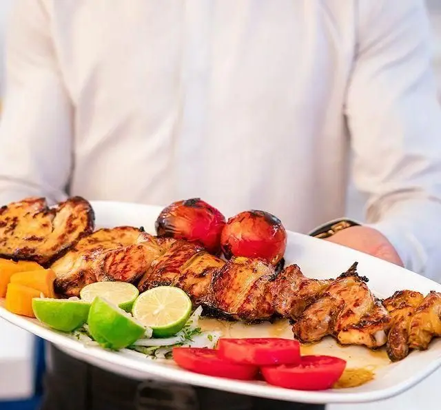 سرو جوجه کباب خوشمزه و تازه رستوران محسن با گوجه کبابی و لیمو، انتخابی عالی برای غذای اصیل ایرانی. لذت طعم بی‌نظیر.