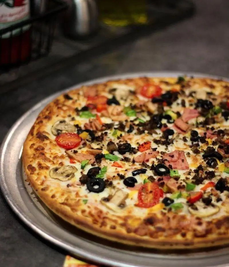 عکس پیتزا مخصوص رستوران بیگ بنگ با ترکیبات متنوع شامل قارچ، زیتون، گوجه‌فرنگی و گوشت، غذایی لذیذ برای تجربه عالی.
