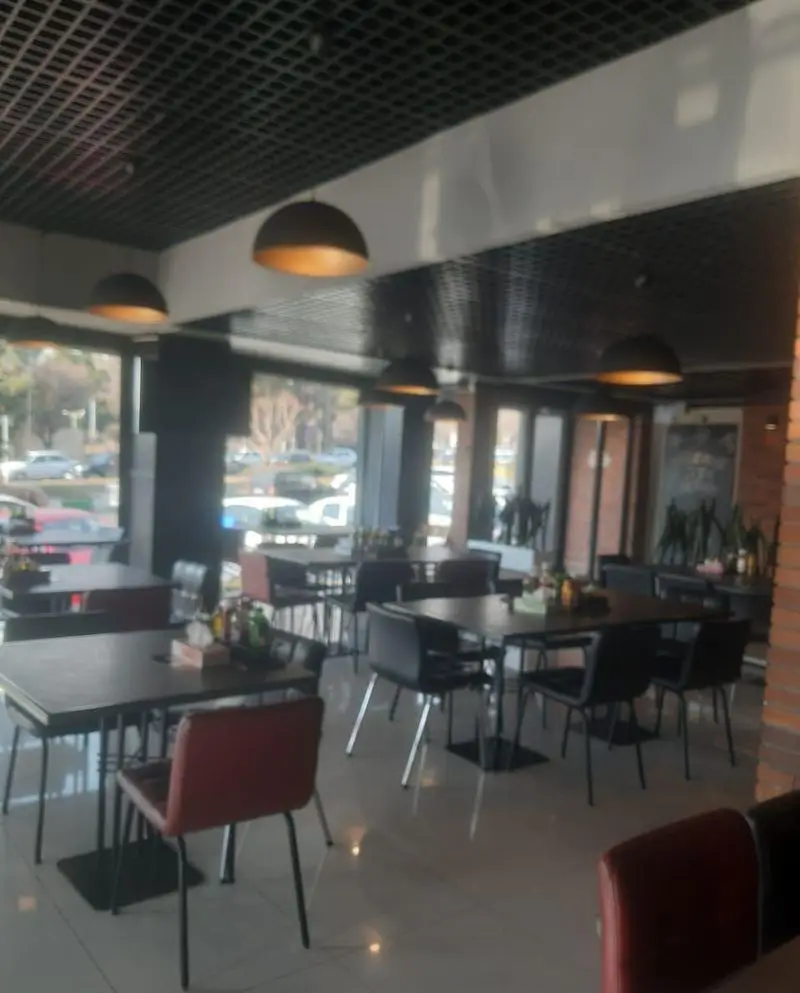 نمایی از دکوراسیون داخلی رستوران بیگ بنگ با میز و صندلی‌های مدرن و نورپردازی جذاب، فضایی ایده‌آل برای صرف غذا و دورهمی.