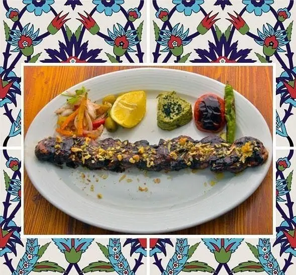 کباب لذیذ رستوران باغ طهرون: سیخ کباب با چاشنی، لیمو، گوجه و فلفل کبابی، همراه با سس و مخلفات در محیط دلنشین.