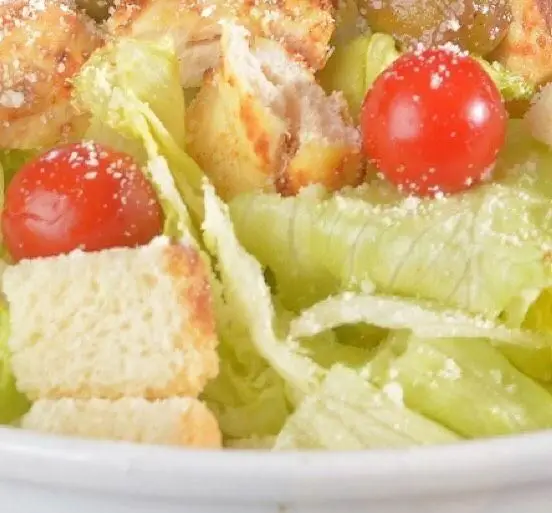 سالاد سزار جذاب و تازه رستوران باغ طهرون شامل کاهوی ترد، گوجه گیلاسی آبدار و نان کروتون طلایی با پنیر پارمزان.