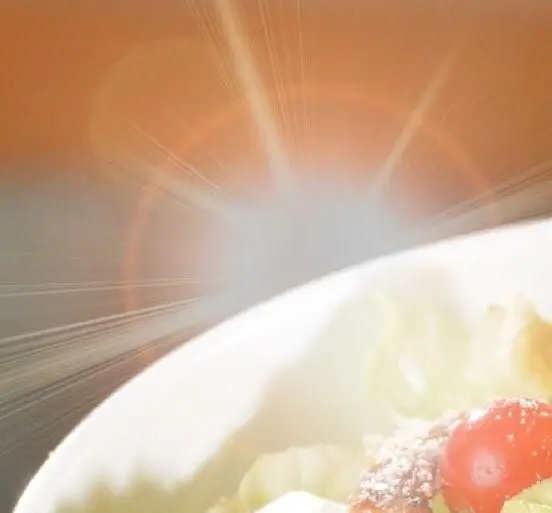 تصویری از یک سالاد اشتهاآور با مواد تازه شامل کاهو و گوجه فرنگی، ارائه شده در رستوران باغ طهرون، با نورپردازی هنری.