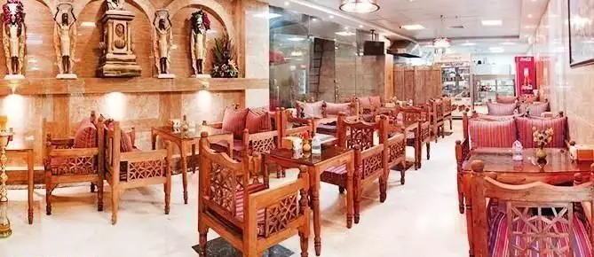 رستوران عربی پالمیرا با دکوراسیون شرقی، مبلمان چوبی منبت‌کاری شده و کوسن‌های قرمز، فضایی آرامش‌بخش و شیک