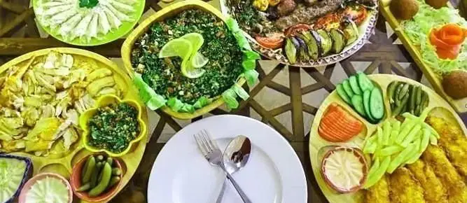 میز پر از غذاهای لذیذ عربی از جمله کباب، سالاد و پیش‌غذاهای متنوع رستوران پالمیرا. تجربه طعم اصیل شرق.