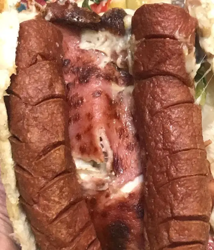 ساندویچ سوسیس ویژه کافه نارنج با سوسیس کبابی و پنیر آب شده، یک وعده غذایی لذیذ و خوشمزه برای تجربه در محیط کافه.