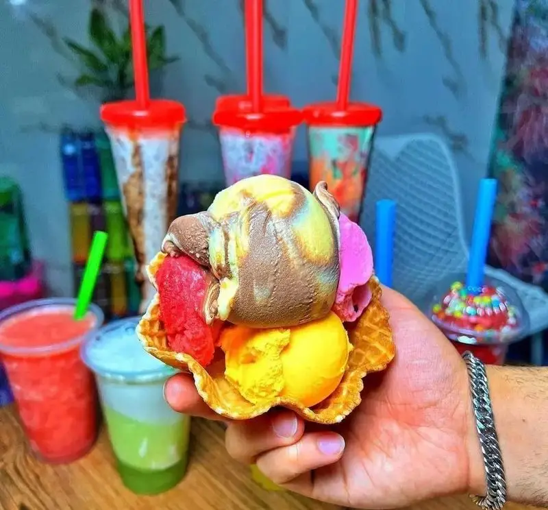 بستنی چند اسکوپ رنگارنگ در ظرف ویفری، در کنار انواع شیک و آبمیوه‌های طبیعی ویتامینه چهارفصل. خنکی لذت‌بخش.