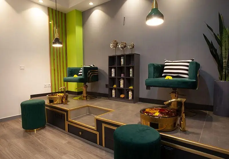 دکوراسیون داخلی فست فود خانه کوچک؛ فضایی مدرن با صندلی‌های راحت سبز، نورپردازی خاص و قفسه‌های دکوری شیک.