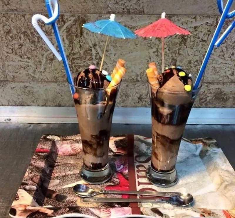 میلکشیک و بستنی شکلاتی خنک و دلپذیر رستوران بی بی گل، با تزیینات رنگارنگ و طعم بی نظیر، مناسب فصول گرم سال.