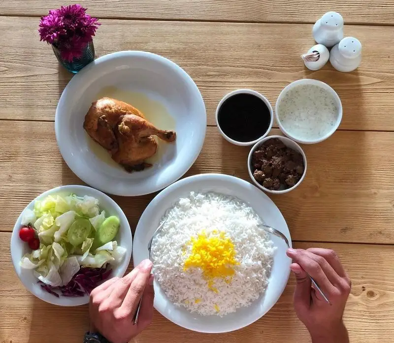 غذای سنتی اکبرجوجه شهرک غرب: مرغ کامل بریان، پلو زعفرانی، رب انار و سالاد تازه. تجربه‌ای لذت‌بخش از طعم اصیل ایرانی.