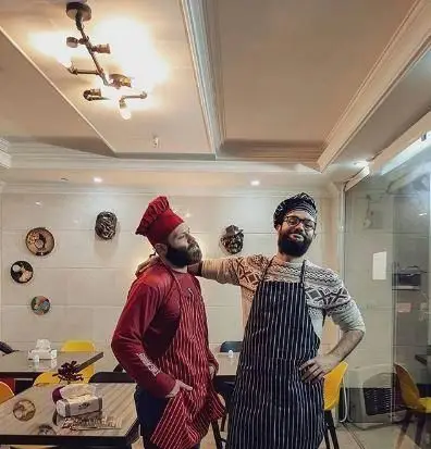 دو سرآشپز مجرب فست فود کره با لبخندی صمیمی، آماده ارائه بهترین غذاها و تجربه‌ای لذت‌بخش در رستوران.