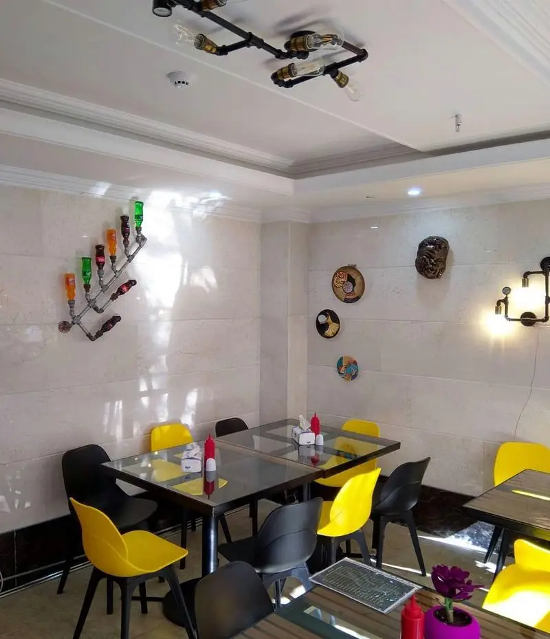 فضای داخلی فست فود کره با دکوراسیون صنعتی و مدرن، شامل میز و صندلی‌های شیک و راحت، مناسب برای تجربه غذایی دلنشین.