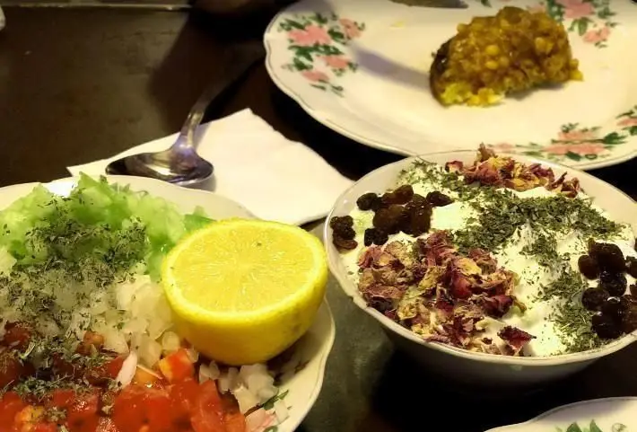 سفره رنگین رستوران ایرانی خونه شامل ماست و خیار، سالاد شیرازی تازه و خورشت اصیل ایرانی. لذت غذای خانگی.